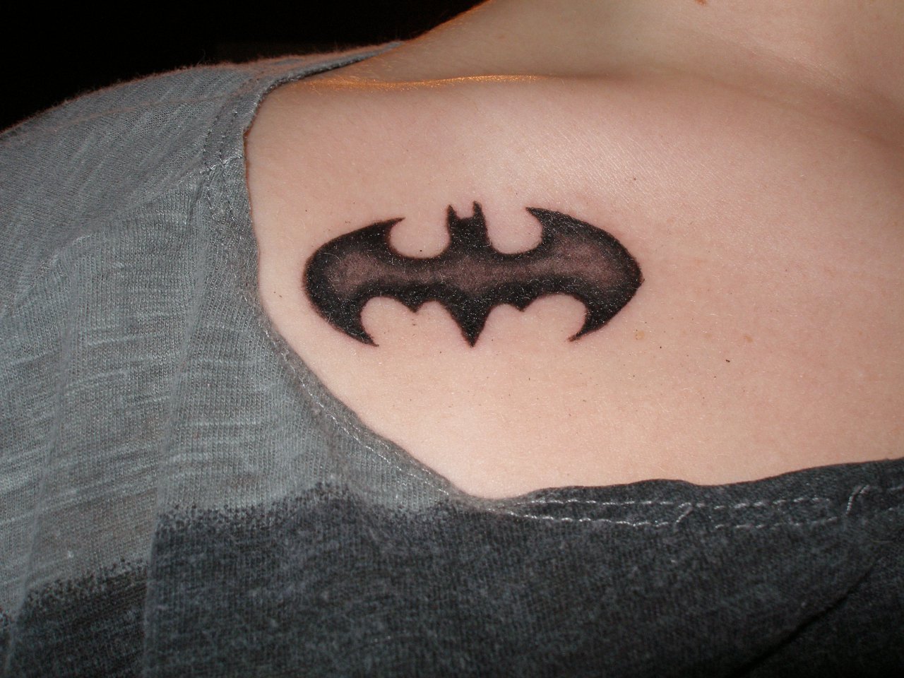 Superman, wonder woman and batman symbols elegantly combined tattoo idea |  TattoosAI